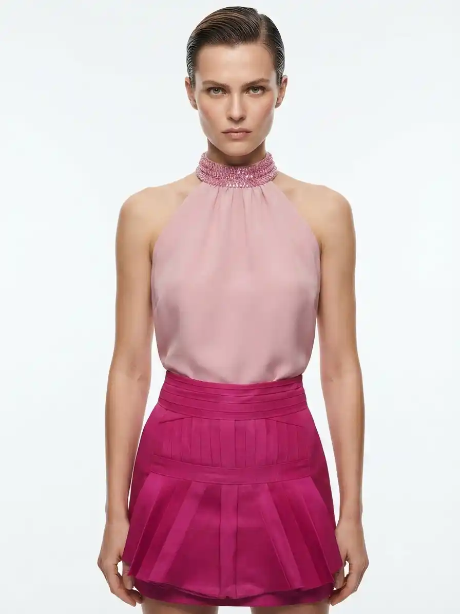 Outfit blusa cuello halter con pedrería y falda plisada